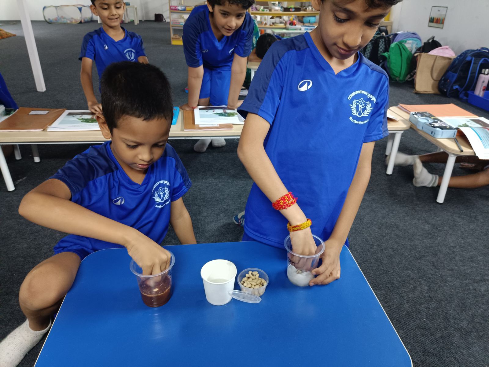 Two boys mix liquids in cups